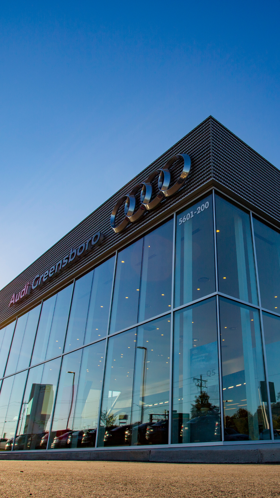 Audi Greensboro dealership storefront with a blue sky in the background