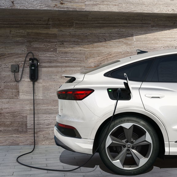 Side view of the Audi Q4 Sportback e-tron® parked and charging.