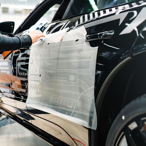 Side of the Audi RS e-tron GT project_513/2 getting a decal installed.