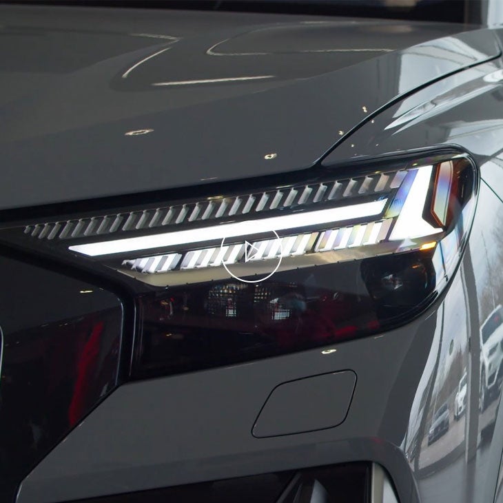 Gros plan du phare d'un véhicule Audi affichant une signature lumineuse personnalisée.