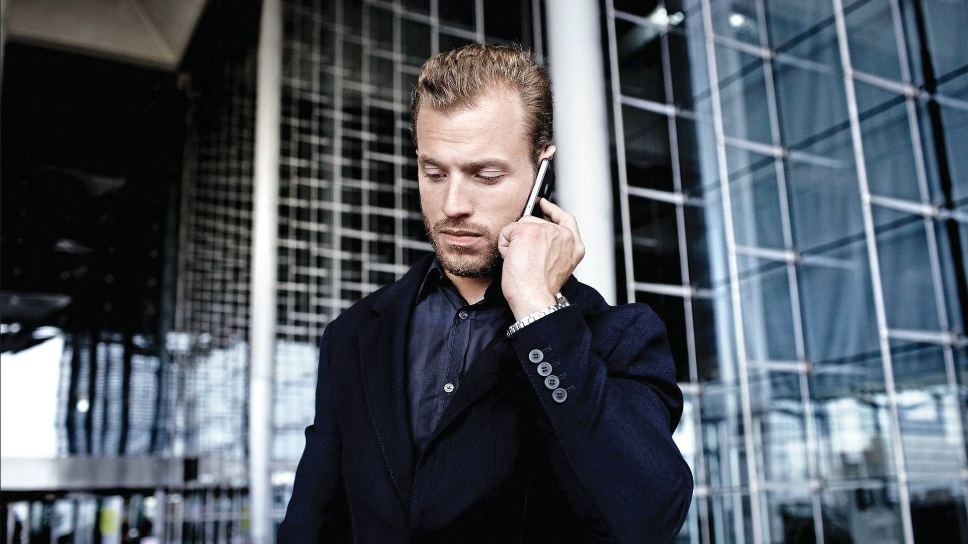 An Audi customer speaking on a smartphone.