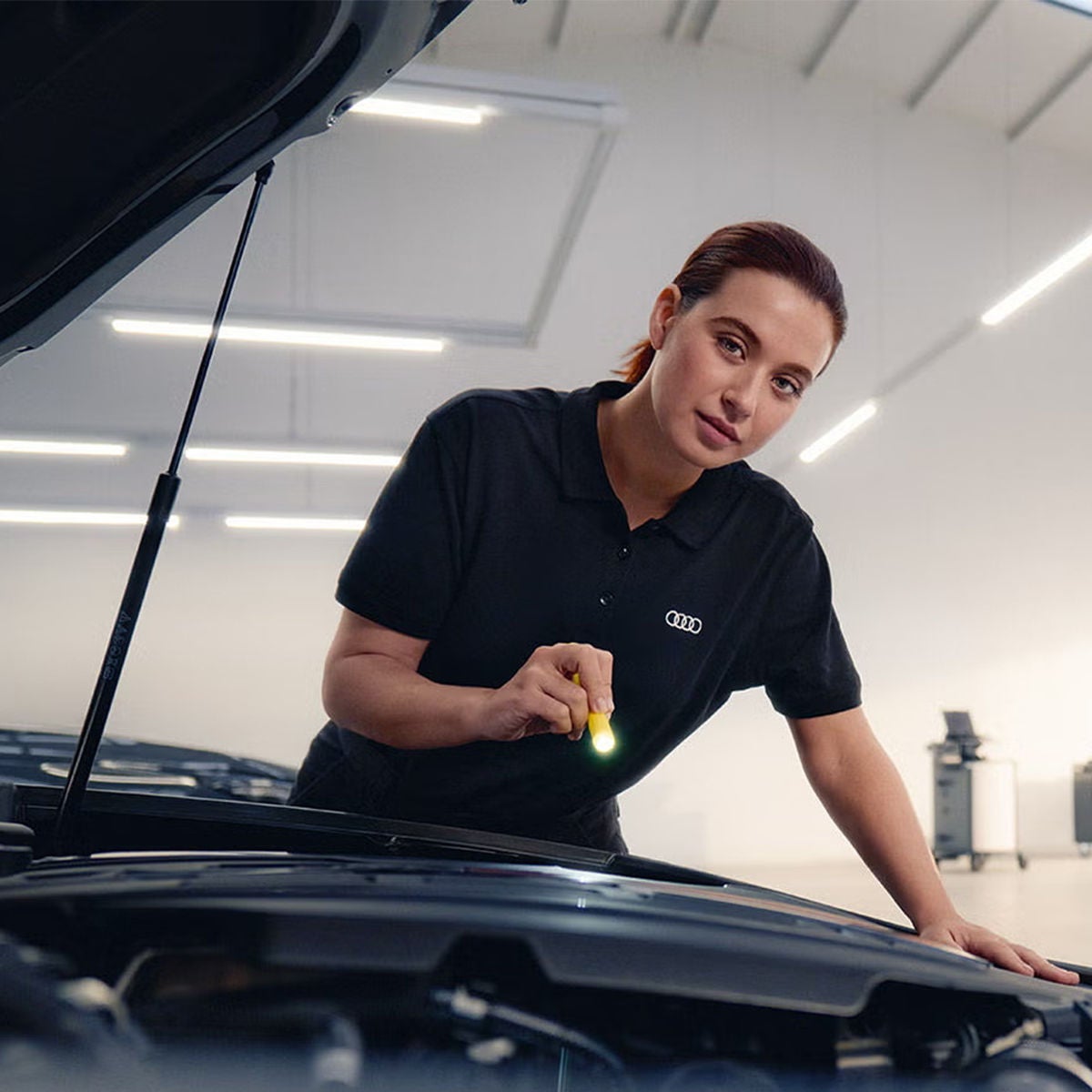 An Audi technician inspecting a vehicle.