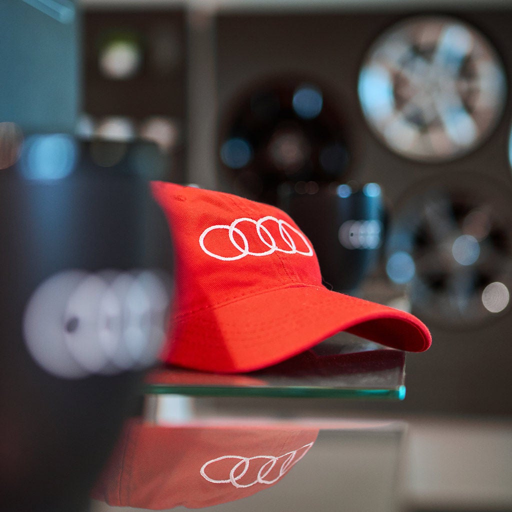 Une casquette avec le logo Audi sur une table.