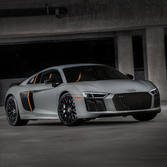 Low-angle shot of a silver Audi R8 in a parking garage, showcasing the Audi laser light. 