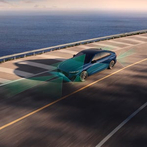 Vue aérienne trois quarts avant de l'Audi S5 accélérant sur une route longeant un cours d'eau, avec des illustrations représentant la fonction d'assistance au régulateur de vitesse adaptatif.