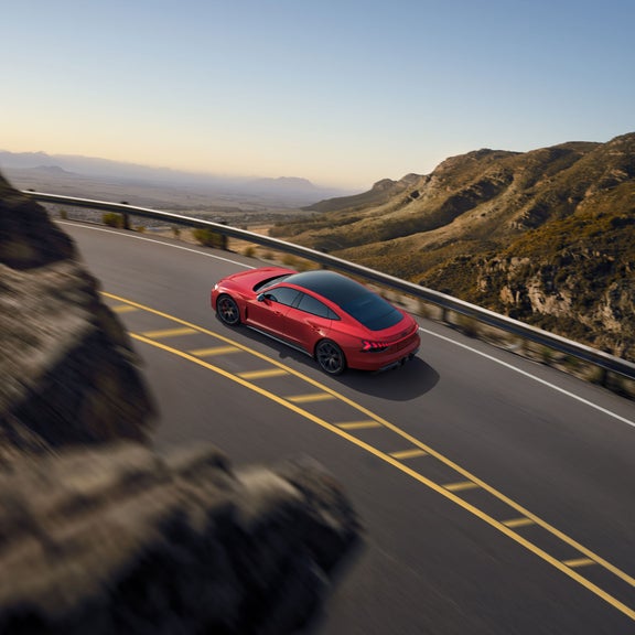 Rear aerial view of the Audi RS e-tron GT in motion. 