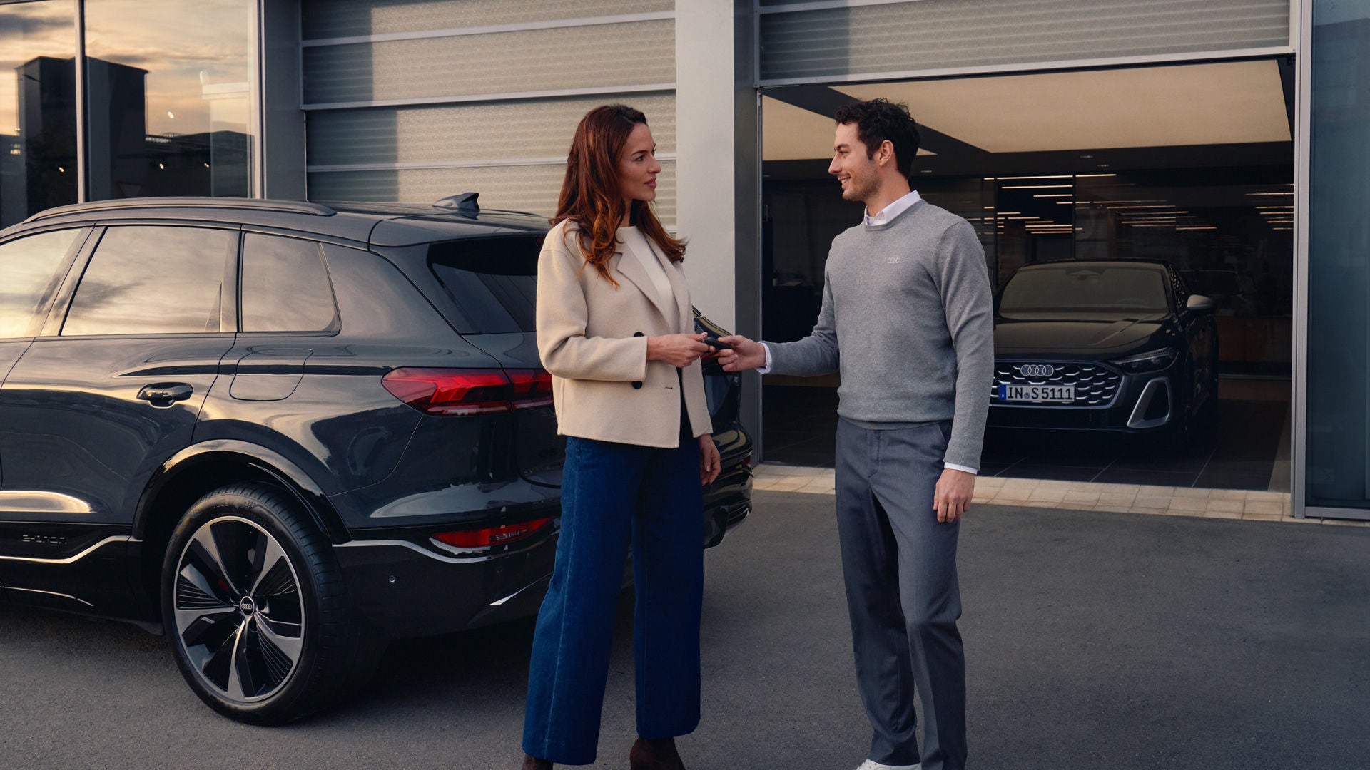 An Audi employee handing the keys to a new Audi owner.