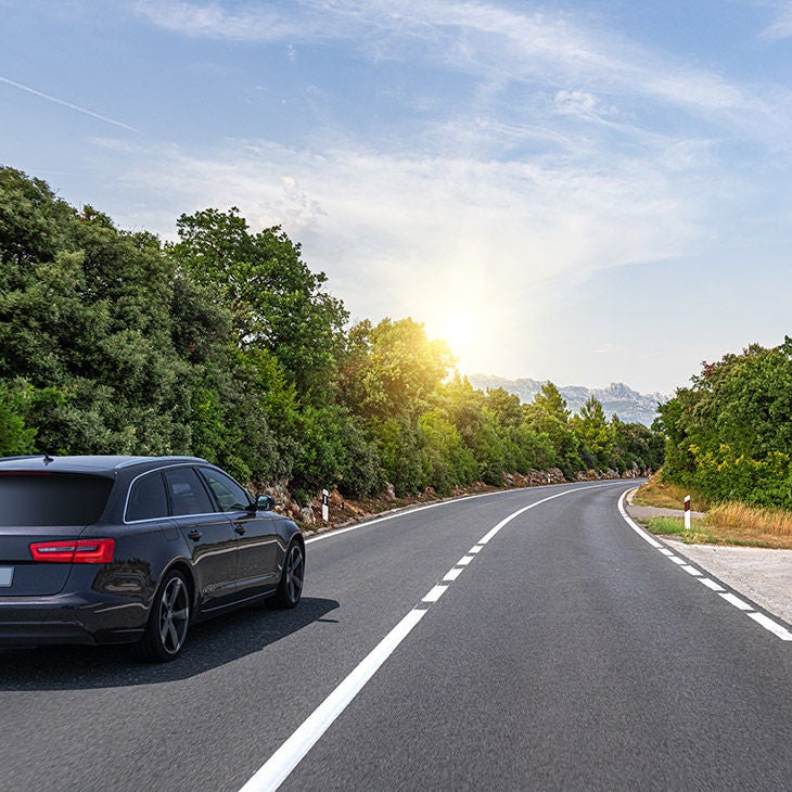 A car driving on a scenic road. 