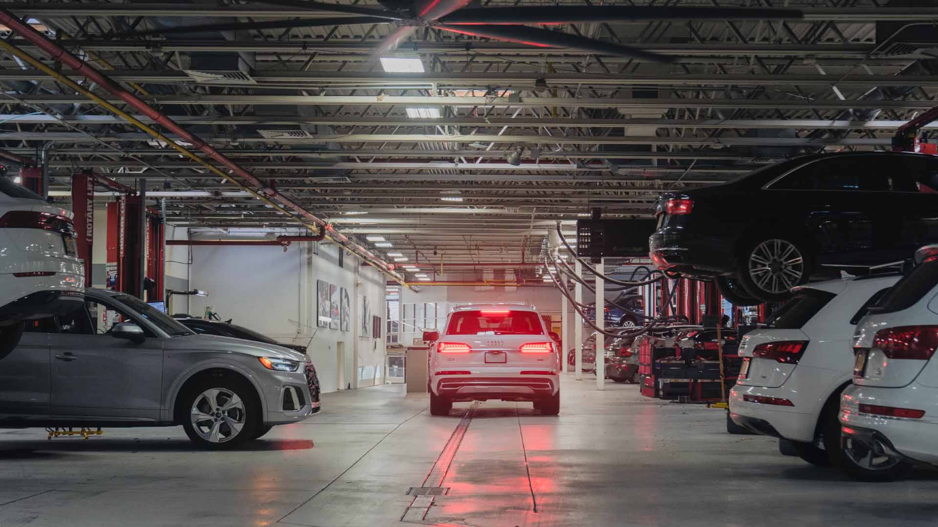 Rear view of an audi vehicle driving through a garage.