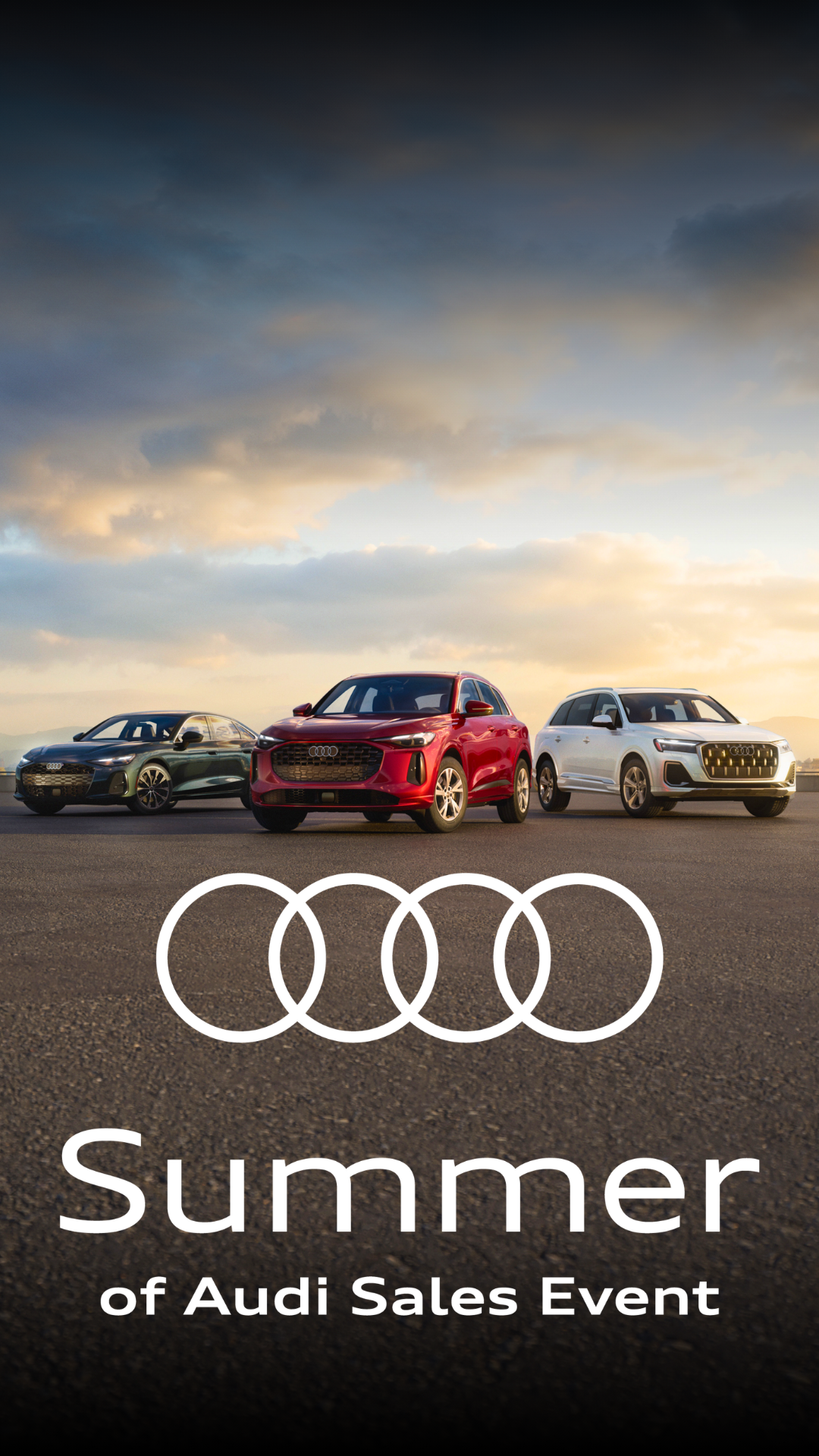 Four Audi vehicles parked side by side with a city skyline in the background.