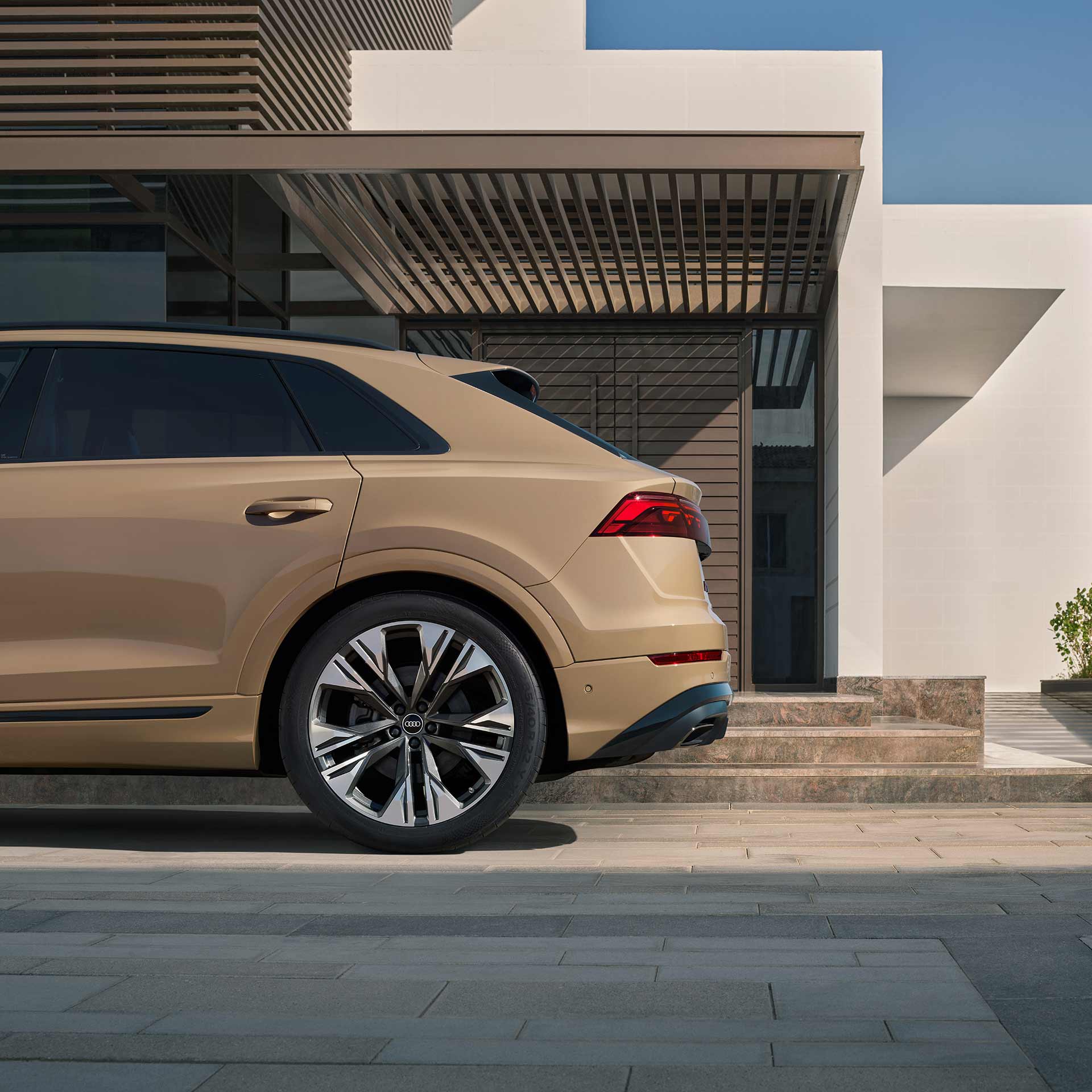 A green Audi A4 allroad crossing a large puddle on a gravel road.