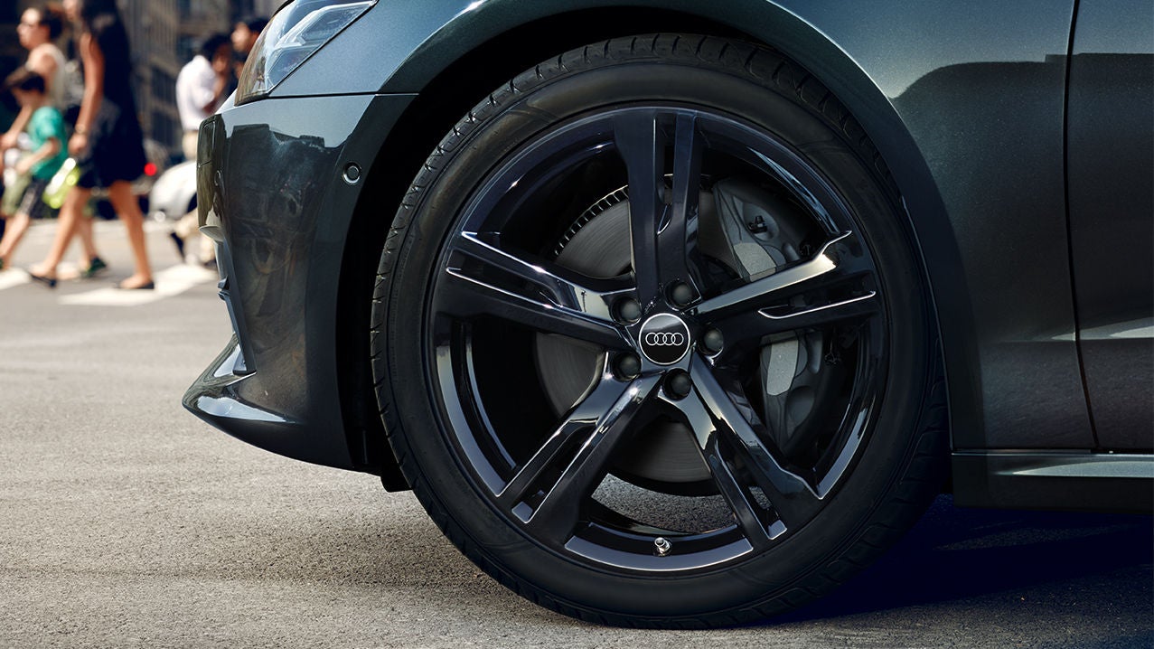 Close-up on the front wheel of an Audi vehicle.