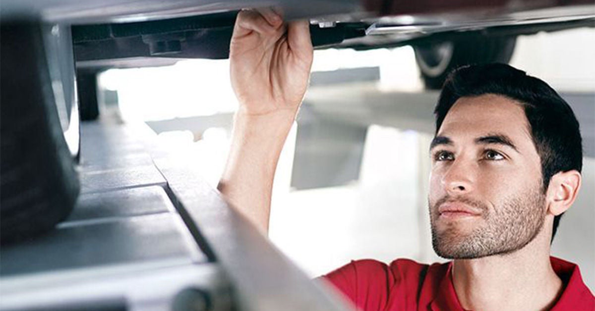 Audi technician inspecting under car