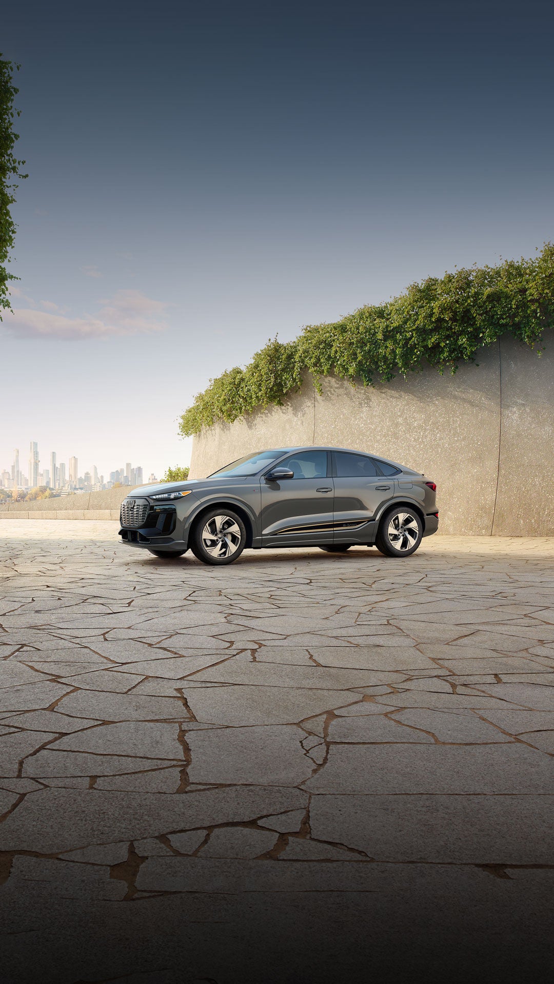 Three-quarter side view of a grey Audi Q6 Sportback e-tron parked.