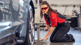 Service technician servicing vehicle. 