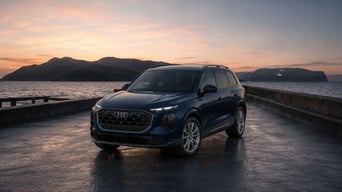 Three-quarter front view of the Audi Q7 parked by a waterfront.