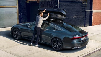 A person opening up their roof box on their Audi vehicle.