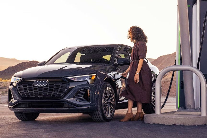 Woman Charging Audi Electric Vehicle
