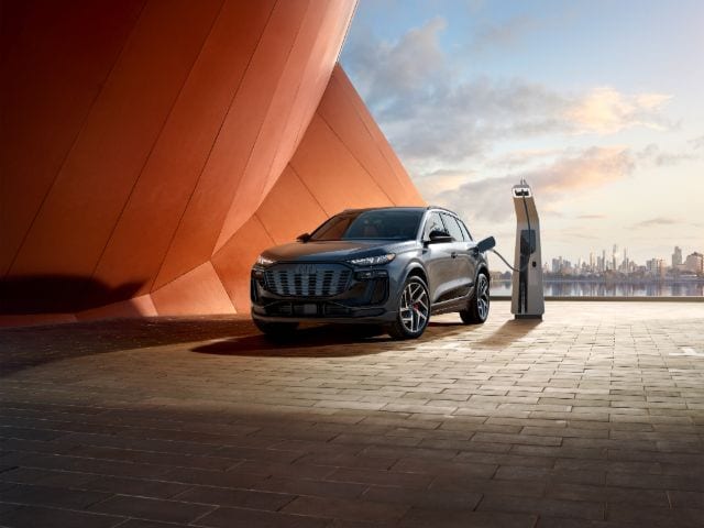 Front view of 2025 Audi SQ6 e‑tron plugged in at charging station