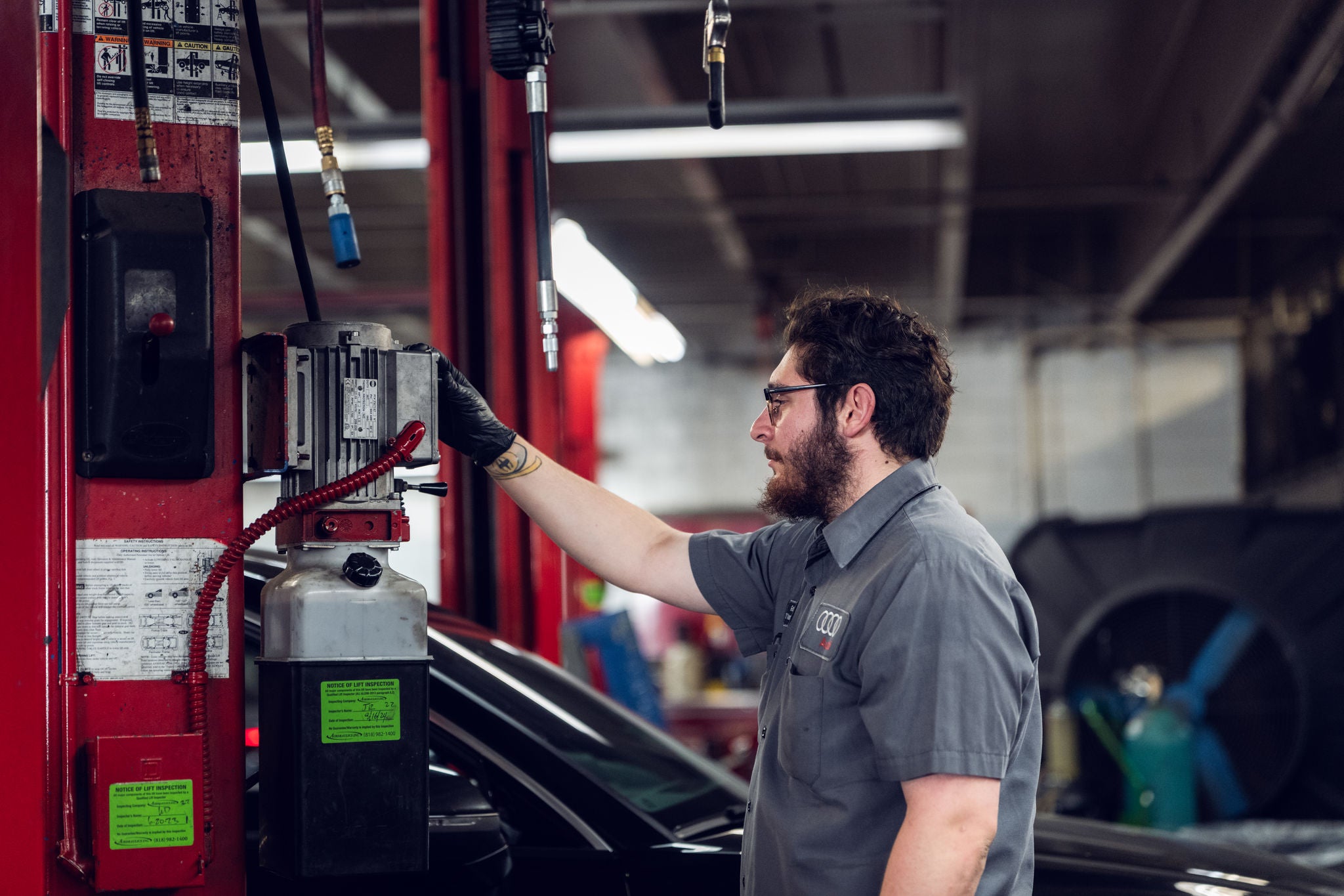 Audi service technician servicing a vehicle.