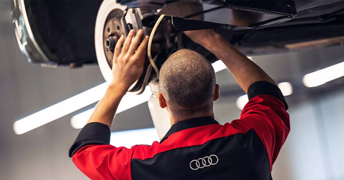 Audi service technician working on brakes