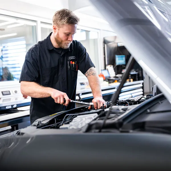Technicien en mécanique inspectant un véhicule dans l'atelier d'Audi de Québec