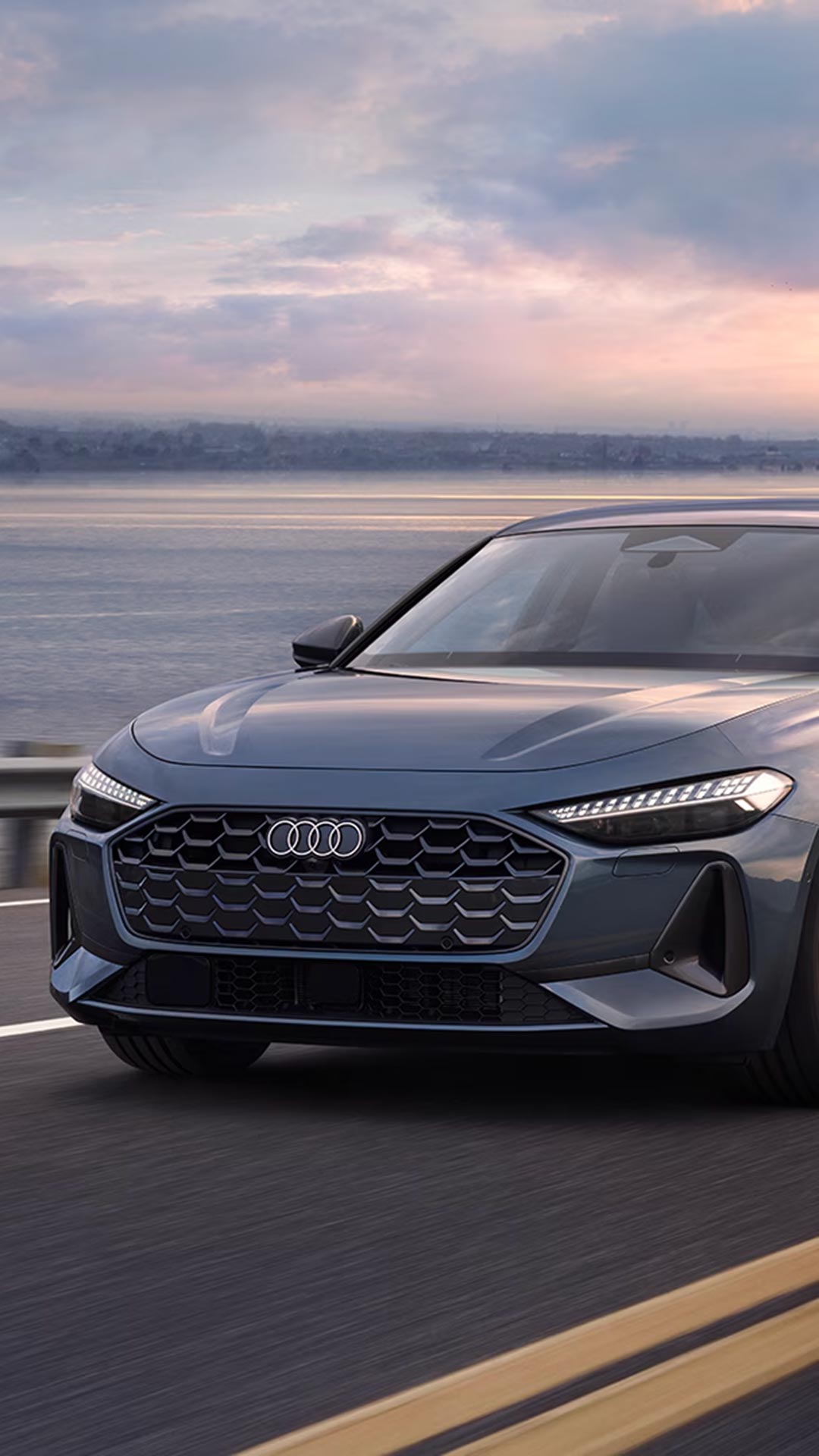 Three-quarter front view of a 2025 Audi A5 model driving on the road.