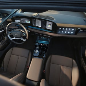 Interior view of the Audi Q6 Sportback e-tron through the sunroof, showing the interior lighting technology.