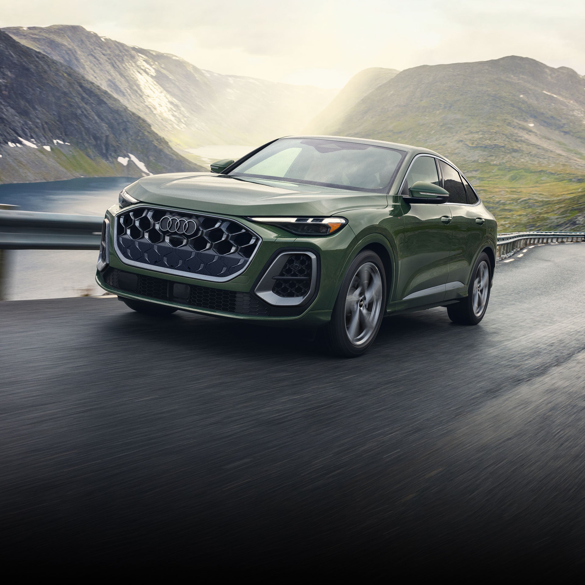 Three quarter front view of the Audi Q5 Sportback accelerating on a mountainside road.