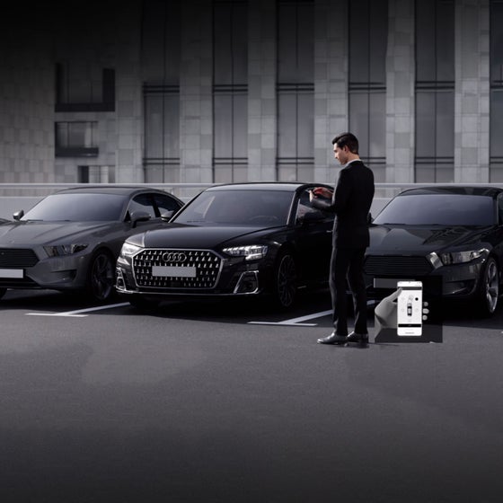 Audi Q8 parked in front of a building, business man standing next to Q8