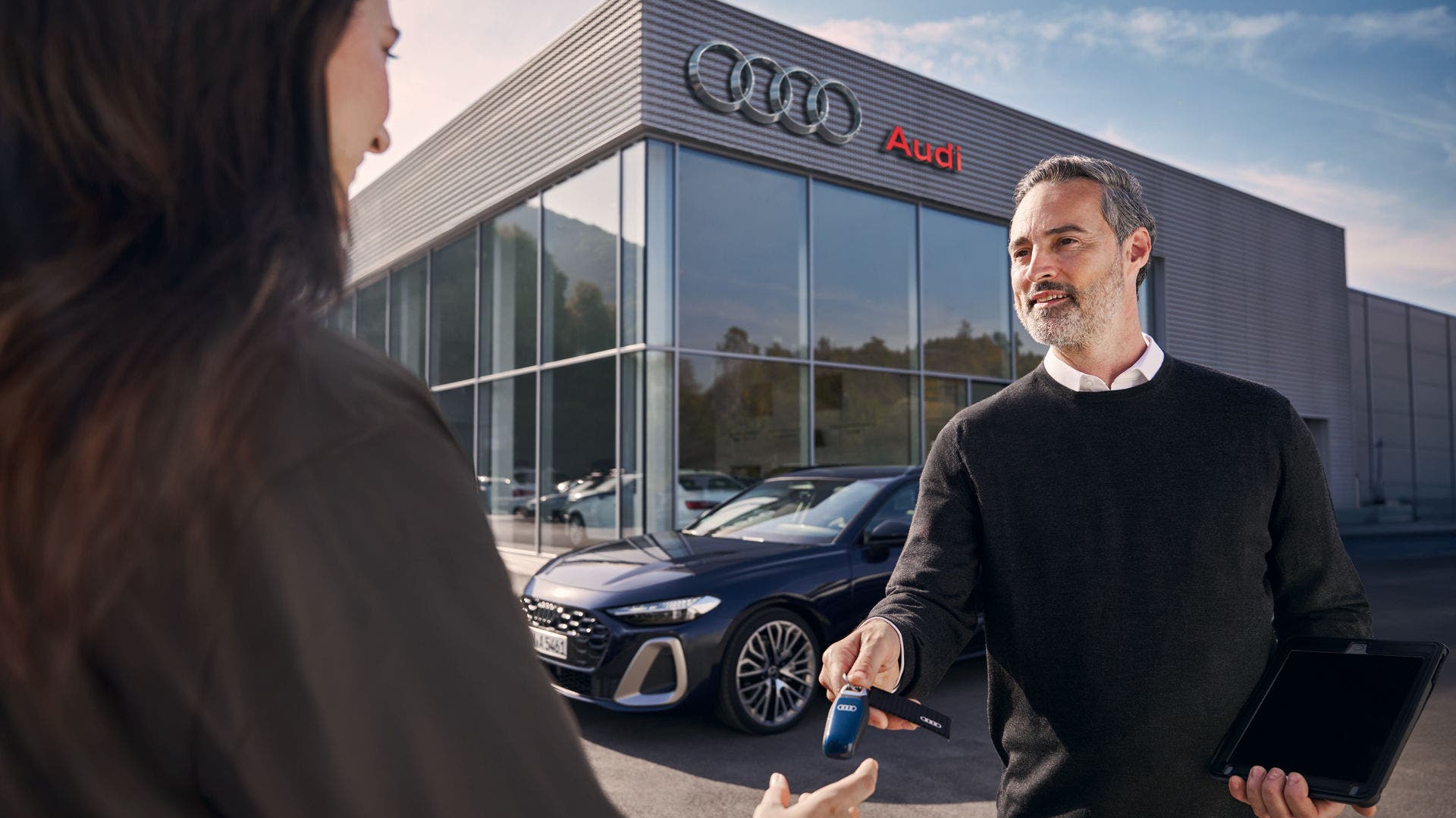 Audi Salesperson shaking customers hand in front of Audi Showroom