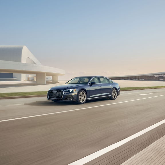 Three quarter front profile of the Audi A8 accelerating.