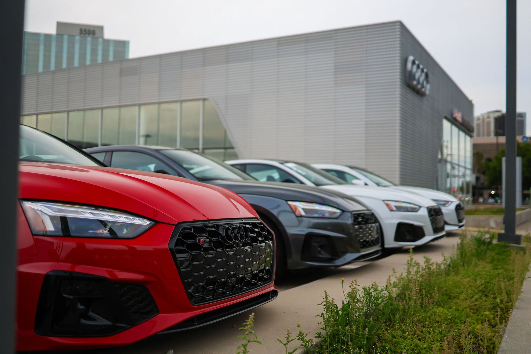 Audi vehicles parked in front of a dealership showroom