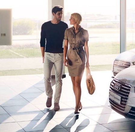 Couple walking in Audi showroom. 