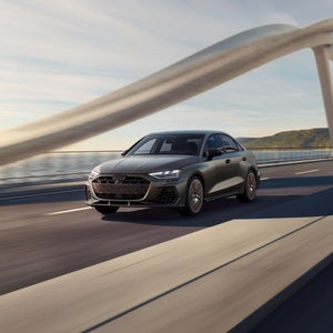 Three quarter front view of the Audi S3 accelerating on a bridge.