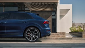 Side profile of a blue Audi Q8 showing its sloping roofline.