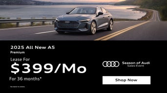 Three quarter view of an Audi A5 driving.