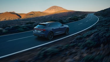 Aerial rear view of the Audi RS Q8 accelerating on a hillside road.