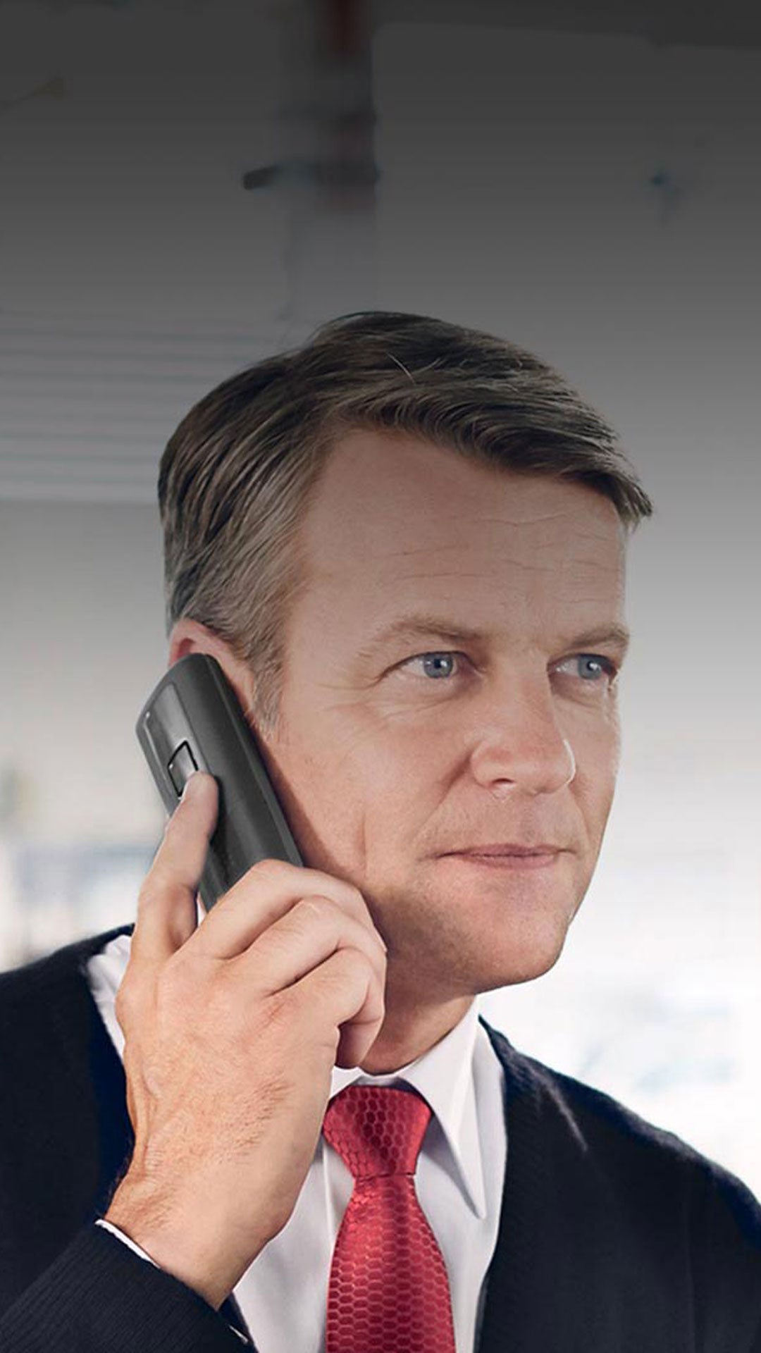 A close-up photo of a man on his phone calling Audi owner assistance.
