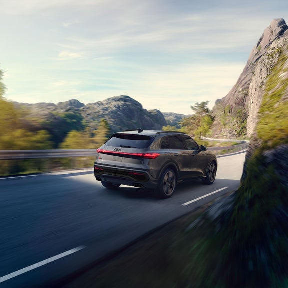 Three-quarter side view of the Audi Q5 parked by a modern building.