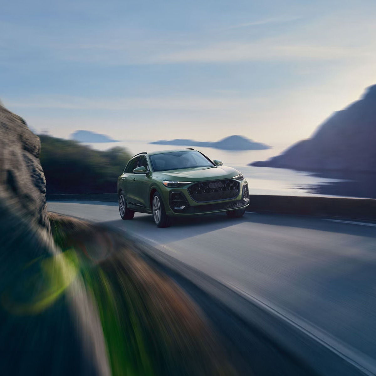 Three-quarter front view of the Audi Q5 accelerating on a mountainside road.