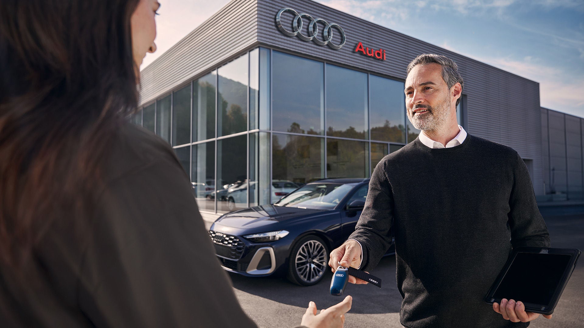 Audi staff handing a loaner key to a customer, Audi Victoria, BC