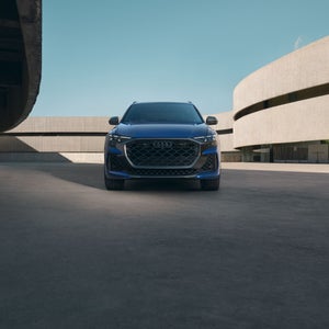 Front profile of the Audi RS Q8, showing lit up LED headlights.