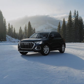 Audi Q3 equipped with winter tires parked on a snow-covered road