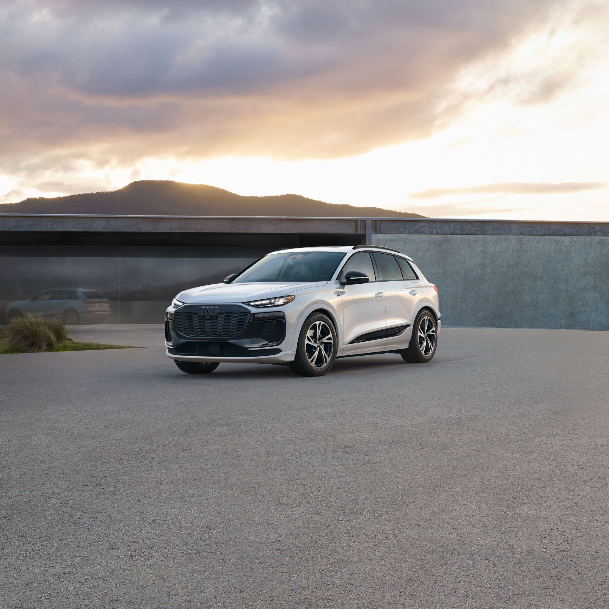 Three-quarter front view of a white Audi Q6 e-tron parked. 