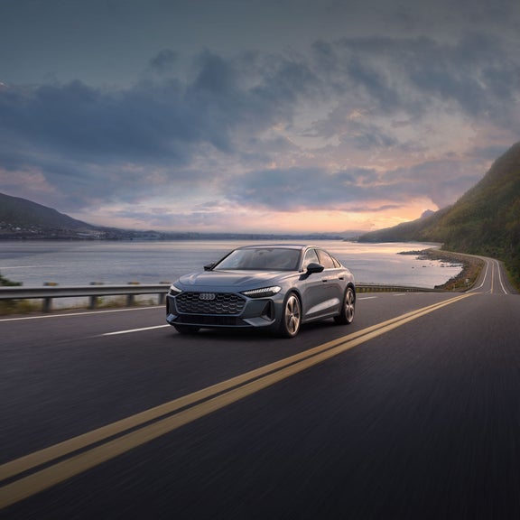 Vue avant de l’Audi A5 qui accélère sur une route au bord de la mer.