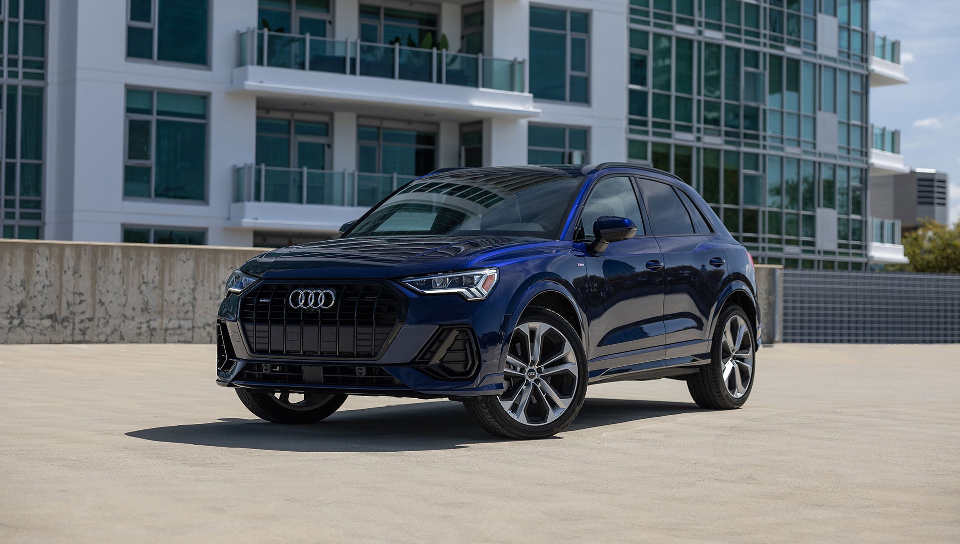 Left side profile view of an Audi vehicle parked.
