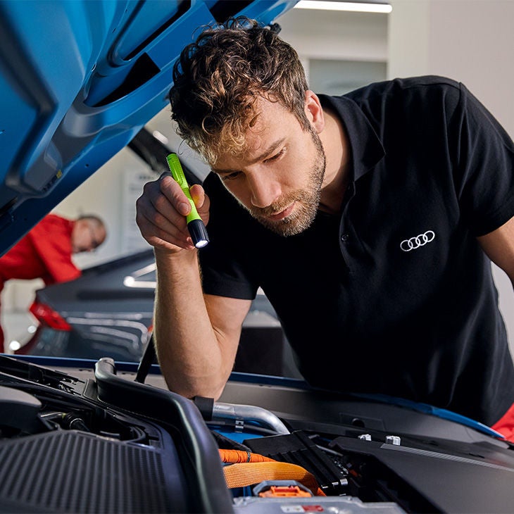 Un technicien Audi inspecte un véhicule Audi.