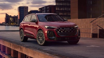 Photo of an Audi SQ5 parked near a pier at sunset.