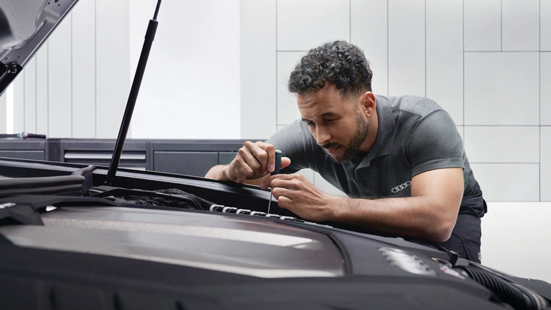 Audi service technician servicing a vehicle.